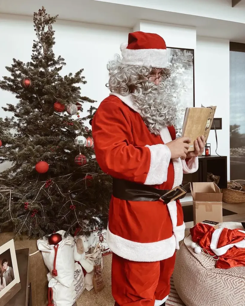 Papá Noel leyendo las cartas junto al árbol de Navidad